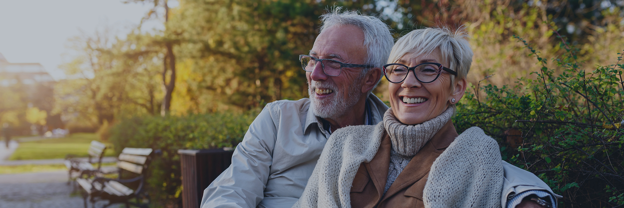 Senior couple smiling outdoors with All-on-4 dental implants in Boca Raton