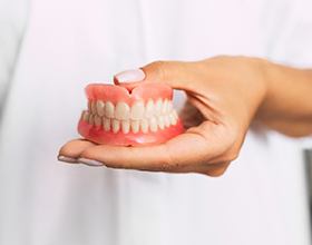 dentist holding full dentures 