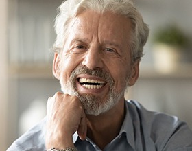 man smiling after getting dentures 
