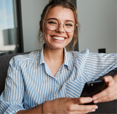 Smiling young woman holding her phone