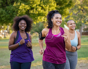 Group of woman smiling while running outside