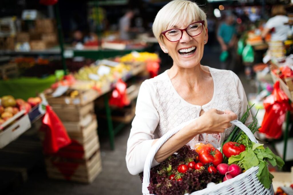 A woman holding a basket of fresh vegetables.